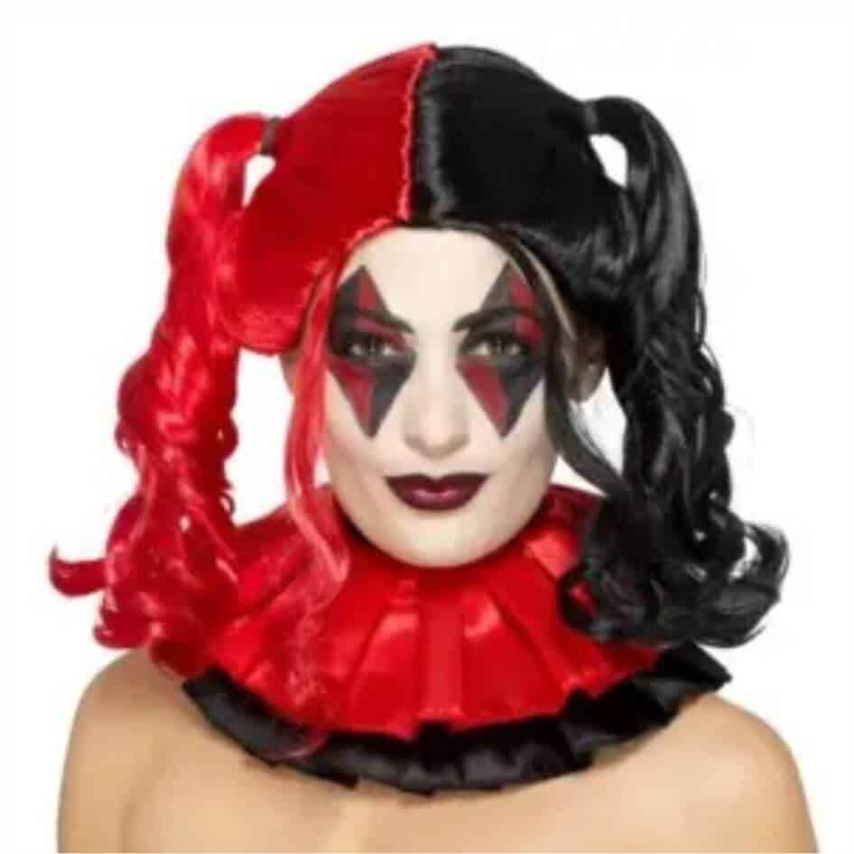 Unleash Your Inner Mischief Maker! Step into the chaotic and whimsical world of the harlequin with our Twisted Harlequin Wig from Joke.ie, Ireland! Perfect for costume parties, cosplay events, theatrical performances, or simply adding a touch of playful mischief to your look, this wig is an essential accessory for anyone looking to embrace their inner jester. Key Features: Distinctive Split Color Design: Featuring a striking black and white split color scheme, this wig embodies the essence of the classic harlequin. The bold contrast ensures you stand out, making a dramatic statement wherever you go. Playful Pigtails: The wig is styled into high, bouncy pigtails, adding a fun and quirky touch to your ensemble. The pigtails are full and voluminous, perfect for creating a dynamic and energetic look. High-Quality Synthetic Fibers: Crafted from premium synthetic fibers, the wig offers a natural look and feel while being durable and comfortable. It’s lightweight, ensuring you can wear it for extended periods without any discomfort. One-Size-Fits-Most Design: Designed to fit most head sizes comfortably, the wig features a stretchy cap that provides a secure and snug fit. It accommodates various head shapes and sizes effortlessly, so you can focus on your performance or party. Easy to Wear and Maintain: Slip it on with ease and enjoy hassle-free styling. The wig is low-maintenance, making it ideal for quick costume changes or spontaneous dress-up sessions. Perfect For: Costume Parties: Be the life of the party with your striking Twisted Harlequin look. This wig is sure to make you the center of attention, adding a touch of playful mischief to any event. Cosplay Events and Theatrical Performances: Perfect for bringing your favorite harlequin characters to life, whether on stage or at a convention. The wig’s dramatic style enhances any costume, ensuring you look the part. Everyday Fun and Creativity: Who says wigs are just for special occasions? Add a bit of whimsy to your daily life or photo shoots with this vibrant and fun accessory. Why Choose Our Twisted Harlequin Wig? Our Twisted Harlequin Wig is more than just a costume accessory; it’s a key to unlocking your playful and mischievous side. Whether you’re channeling a classic jester, a comic book villain, or your own unique creation, this wig helps you express your creativity with flair and authenticity. The high-quality construction ensures that you not only look great but also feel comfortable, no matter the occasion. Order your Twisted Harlequin Wig today and embrace the whimsical world of the harlequin with style and fun! We recommend the use of a Wig Cap  with all wigs for extra comfort.