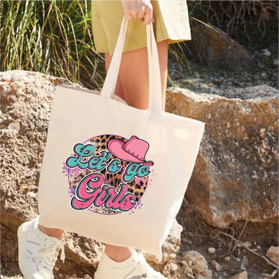 Shania Twain Tote Bag- Lets Go Girls from joke.ie Ideal for all you Shania Twain fans.Our natural colour bags are made from eco-friendly organic cotton and manufactured by a fair-trade business. Dimensions are 39(h) x 35(w) with 30cm handle. Shania Twain Tote Bag- Lets Go Girls